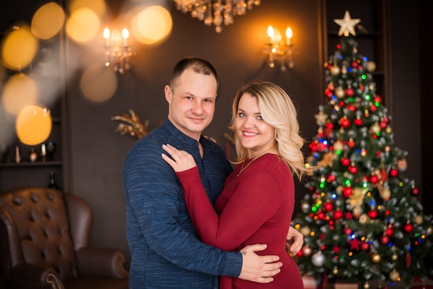 Merry Christmas and Happy Holidays. family, portrait of a man and a woman on the background of a Christmas tree. Happy New Year Greetings