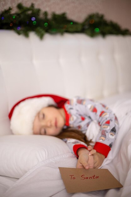 Merry Christmas and Happy Holidays The little  girl sleep on the bed wrote a letter to Santa Claus