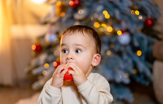 Merry Christmas Happy kleine peuter jongen spelen in de buurt van de kerstboom Mooie baby geniet van kerstmis