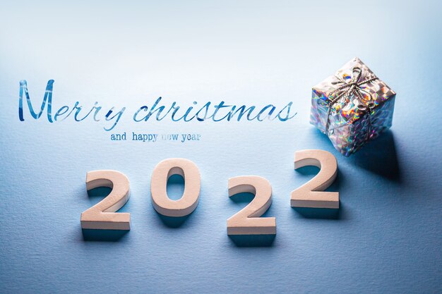 Merry christmas and happy new year 2022 with a giftPostcard with christmas present boxNumbers 2022