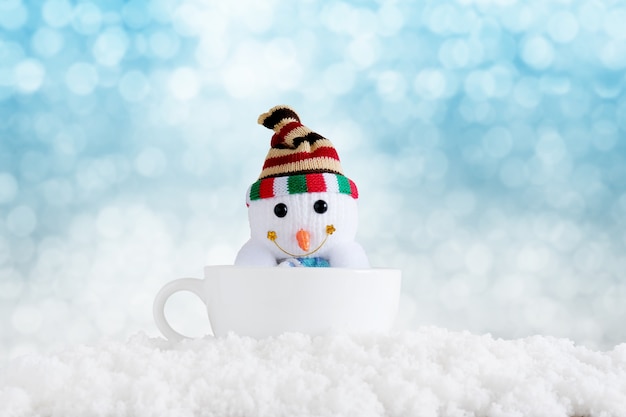 Merry christmas and happy new year background. Snowman in cup with winter background.