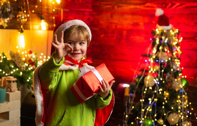 メリークリスマス、そしてハッピーニューイヤー。幸運をお祈りしています。家族の休日。クリスマスプレゼント。かわいい小さな男の子はクリスマスツリーの近くで遊ぶ。子供は家で冬休みを楽しんでいます。喜びと愛に満ちた家