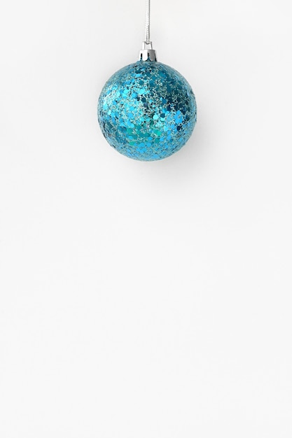 Merry Christmas and Happy New Year Christmas blue ball hanging on a string on a shimmering shiny
