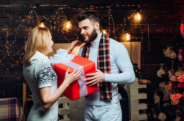 Merry christmas and happy new year. Christmas gifts. Man handsome with gift box surprise for girlfriend. Man hipster give gift to girl christmas decorations background. Surprise for sweetheart