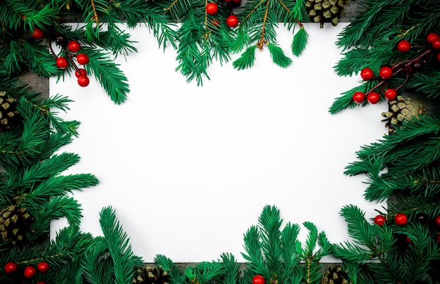 メリー クリスマスと新年あけましておめでとうございますモックアップ ポストカードとコピー スペースと白い背景の上のクリスマス ツリーの枝トップ ビュー クリスマス背景