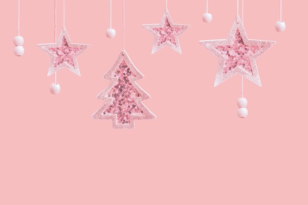 Merry Christmas and Happy New Year pink background Hanging pink star and Christmas tree toys