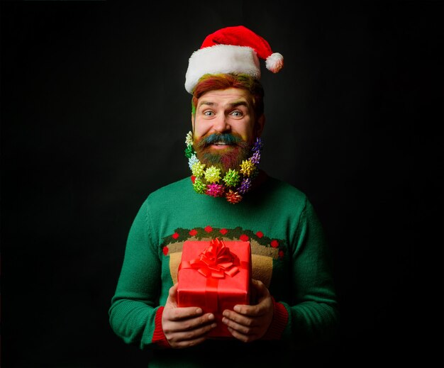 Merry Christmas Happy New year Smiles man in Santa hat with present Santa man with Christmas gift