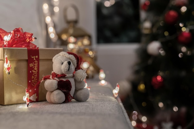 Merry Christmas and Happy New Year. Winter season holiday decoration with teddy bear and gift at home.