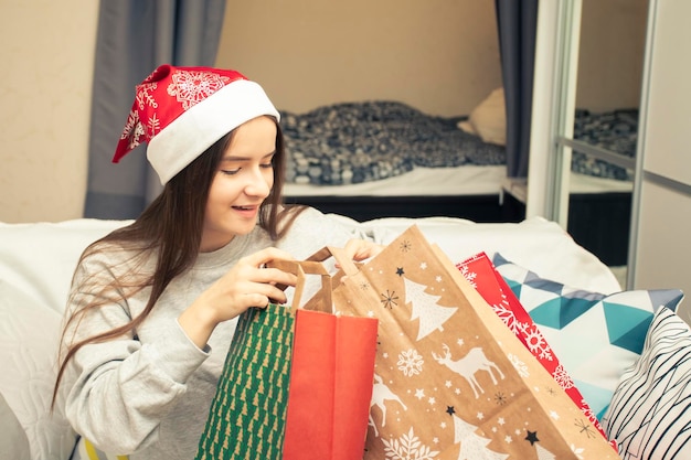 Счастливого Рождества и счастливого Нового года Молодая женщина дома упаковывает подарки и подарки