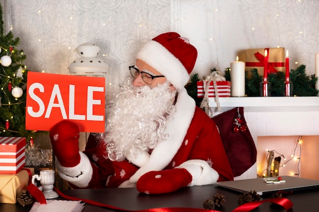 Photo merry christmas holiday sale discount santa claus holding sale sign shopping concept