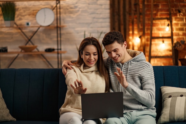 Merry Christmas. Portrait of smiling family using laptop for online meeting, video call, video conference with parents, children, relatives. Winter holidays, Christmas celebrations, New Year concept.