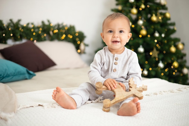 Foto merry christmas portret van een schattig klein meisje van een jaar oud in een knusse slaapkamer, gekleed voor de vakantie lifestyle