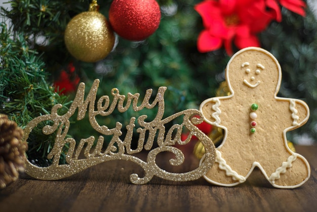 Merry Christmas sign with gingerbread man cookie and decorations on a Christmas tree