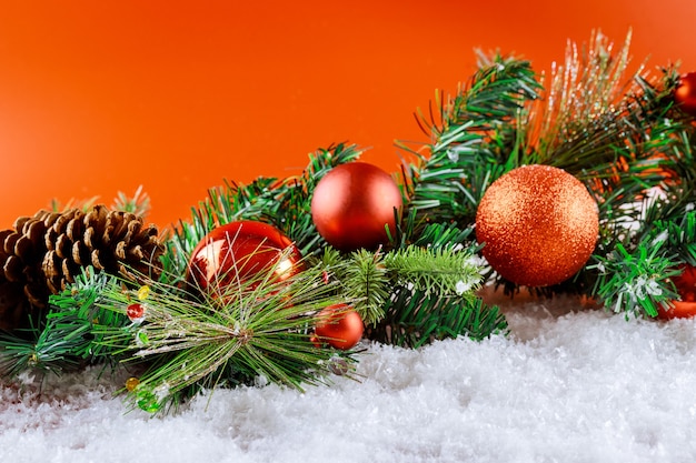 Merry christmas snow decorations on fir branch with pine cone, snowflakes in christmas balls