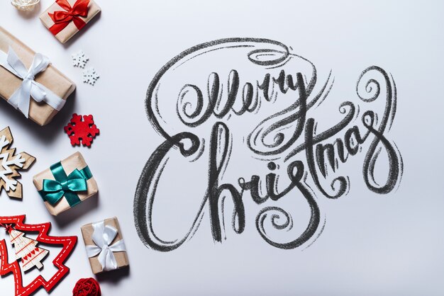 Merry Christmas wishes written with calligraphic font. Lettering. Top view, flat lay.