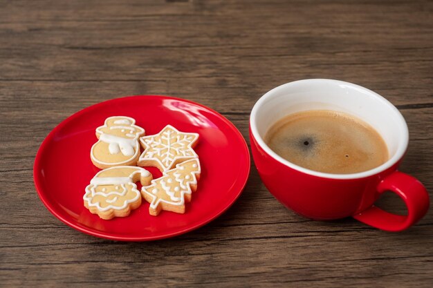 나무 테이블 배경에 홈메이드 쿠키와 커피 컵이 있는 메리 크리스마스. 크리스마스 이브, 파티, 휴일 및 새해 복 많이 받으세요 개념