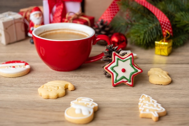 Buon natale con biscotti fatti in casa e tazza di caffè sul fondo della tavola in legno. vigilia di natale, festa, vacanza e concetto di felice anno nuovo