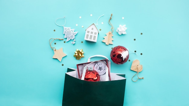 Buon natale con elemento prop ornamento e shopping bag su sfondo colorato.