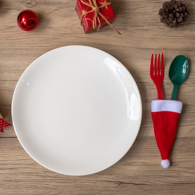 merry christmas with plate fork and spoon on wood table background xmas party and happy new year concept