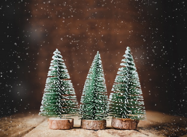 写真 クリスマスツリーと雪が木のテーブルに落ちるメリークリスマス
