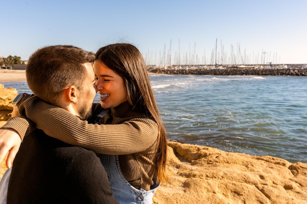 Merry couple touching noses near sea