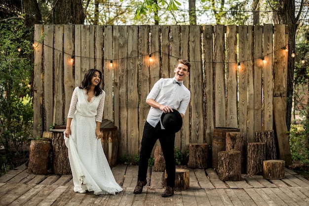 Merry happy young couple have fun near a wooden installation