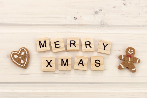 Merry xmas with gingerbread and wooden letters text on a bright background