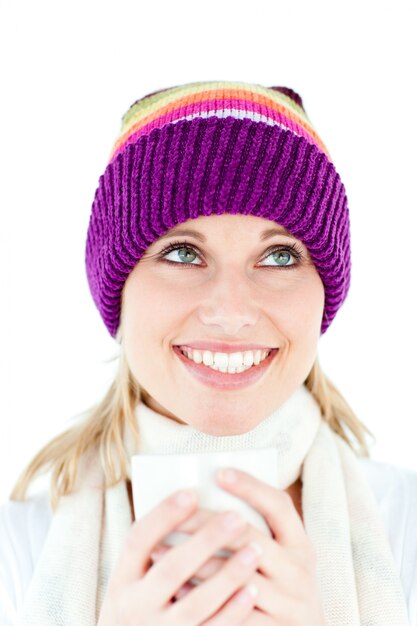 Giovane donna allegra che tiene una tazza che indossa un cappuccio in inverno