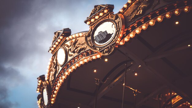 MerryGoRound karrousel verlicht bij nachtreflectie stadsbeeld tegen avondhemel in de zomer festival happy time idee