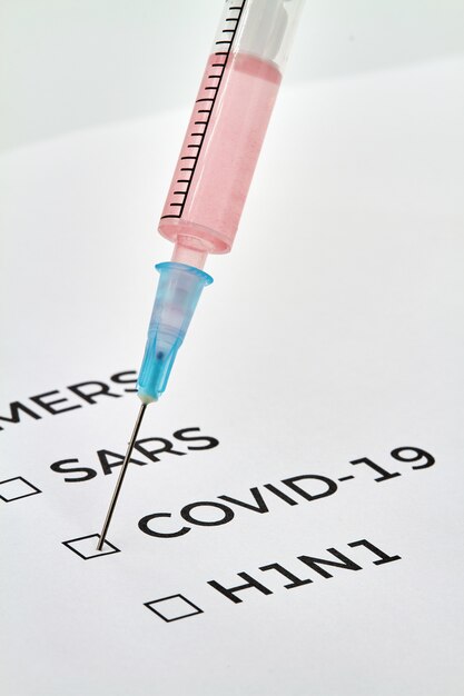 MERS, SARS, COVID-19, H1N1 written on a sheet and a syringe