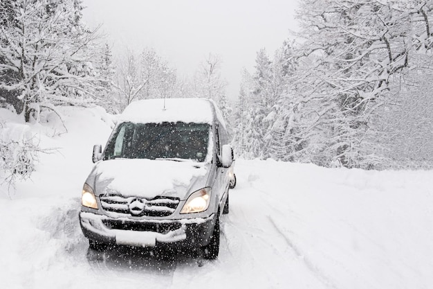 Mersedes sprinter on a snowcovered slippery road road  Winter landscape Driving a car in extreme