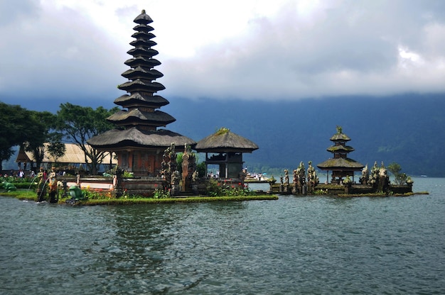 Foto torri meru di pura ulun danu bratan o pura bratan hindu shaivite shiva sito archeologico del tempio per i viaggiatori che le persone viaggiano visitano e rispettano pregando nel lago bratan vicino a bedugul a bali indonesia