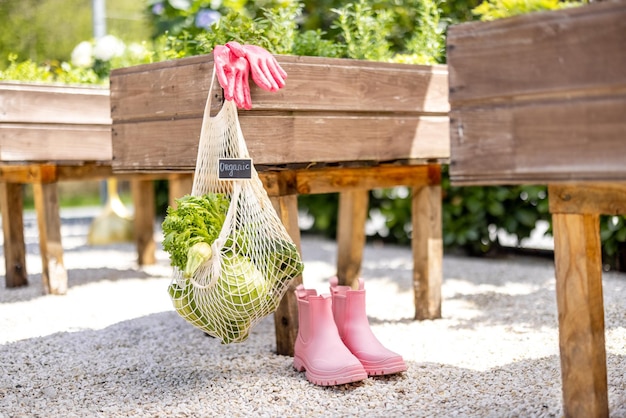 家庭菜園にぶら下がっている新鮮な野菜がいっぱいのメッシュバッグ