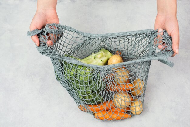 Mesh bag vegetables shopping grocery healthy food ingredients potato broccoli and carrots zero waste