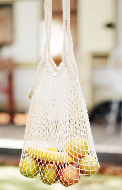 Mesh bag with fruits in female hand hold mesh shopping bag. reusable shopping zero waste concept