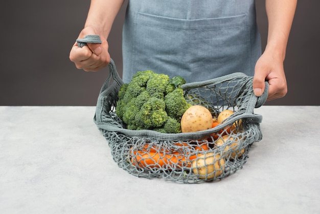 Mesh bag with vegetables shopping grocery healthy food ingredients potato broccoli and carrots