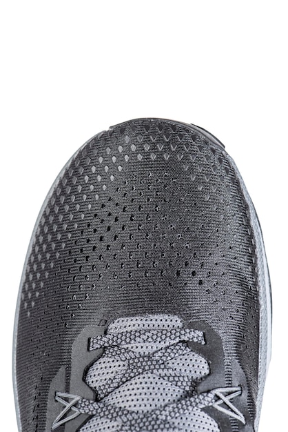 Mesh-stof van sportschoenen in grijze kleur op een afgelegen witte achtergrond Schoenen gemaakt van mesh-stof met een textielstructuur voor een actieve levensstijl en sport Moderne sneakers close-up