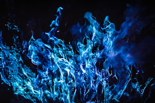 Photo the mesmerizing blue flames danced gracefully against the pitchblack backdrop