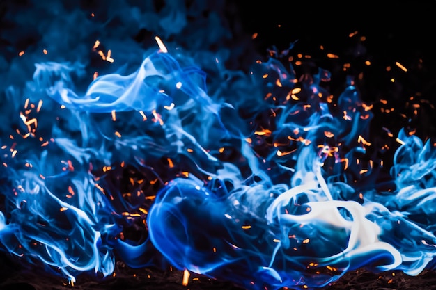 Foto le affascinanti fiamme blu danzavano graziosamente sullo sfondo nero come il fango.