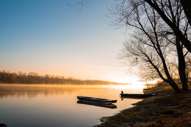 Mesmerizing shot of boats on the calm lake water at sunrise