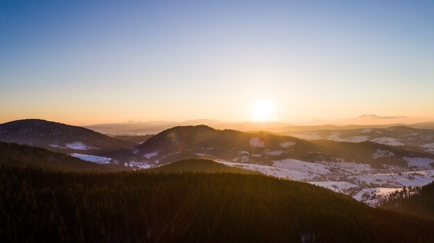 Mesmerizing soothing landscape of hills and mountains covered with snow sunny warm winter evening