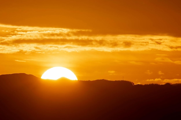 山の後ろに沈む夕日の魅惑的な夕日の景色