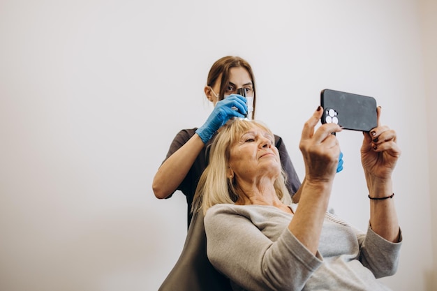 Mesotherapie haarbehandeling Rijpe vrouw met haaruitval die een behandeling krijgt in de kliniek Cosmetica voor versterking en haargroei