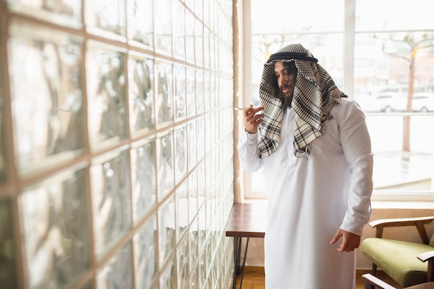 Фото Сообщение. арабский бизнесмен, работающий в офисе, бизнес-центре с помощью устройства
