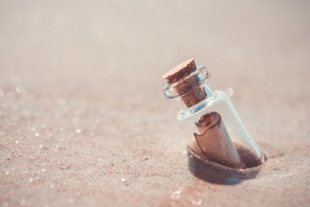 Message in the bottle washed out from sea against the sun setting down