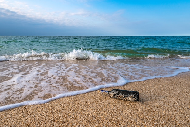 Un messaggio in una bottiglia tappata sulla spiaggia deserta