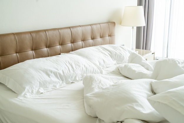 Messy bed with white pillow and blanket on bed