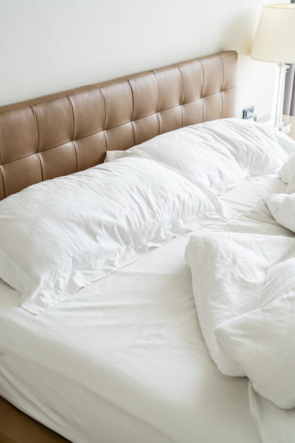 Foto letto disordinato con cuscino bianco e coperta sul letto