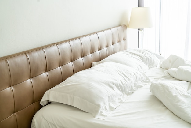 Messy bed with white pillow and blanket on bed