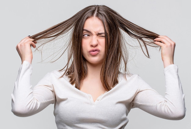 Messy hair. Brunette woman with messed hairs. Girl having a bad hair. Bad hairs day